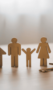 wooden-family-figures-and-house-with-keys-on-table-.jpg Wooden family figures and house with keys on table.